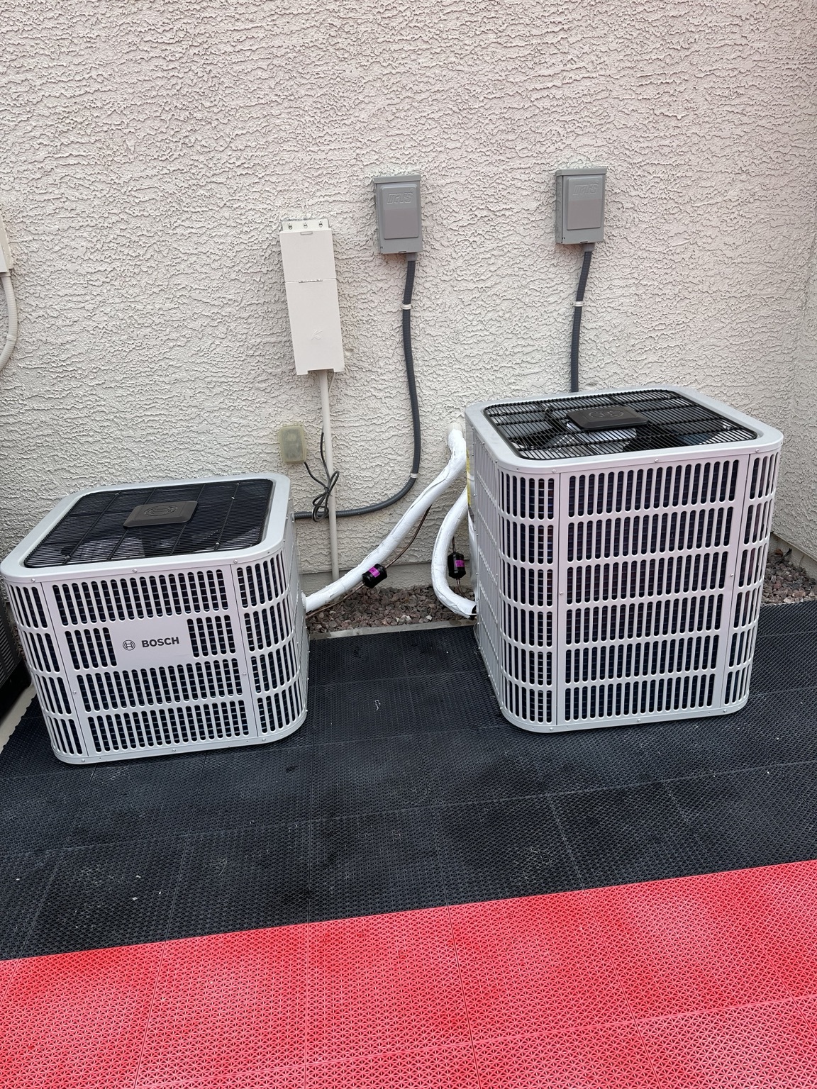 Heating, Furnace & AC Repair in Las Vegas, NV Two Bosch outdoor HVAC units beside a stucco home.