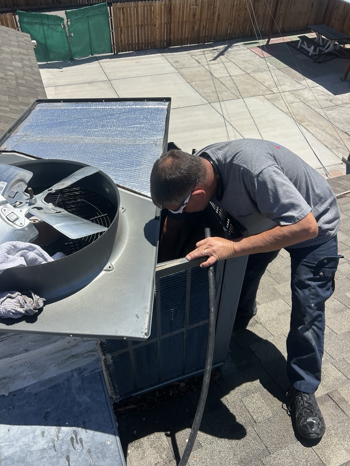 Heating, Furnace & AC Repair in Las Vegas, NV A 32 Degrees technician working inside an opened rooftop air-conditioning unit.
