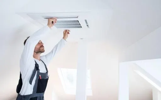 Replacing a ceiling air filter to keep an HVAC system running efficiently in Las Vegas