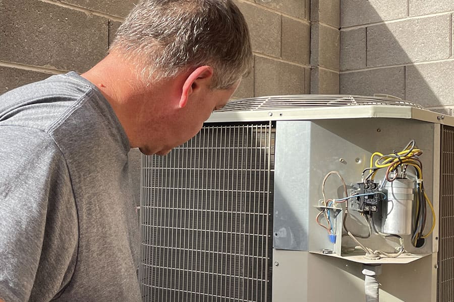 32 Degrees technician replacing AC capacitor on outdoor condenser unit in Las Vegas