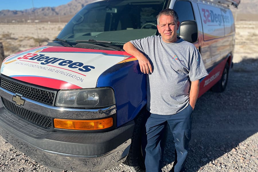 32 Degrees technician standing beside branded service van
