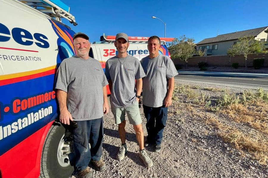 32 Degrees HVAC team standing beside branded service van