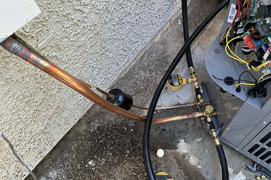 Outdoor AC service hoses attached during tune up in Las Vegas, NV