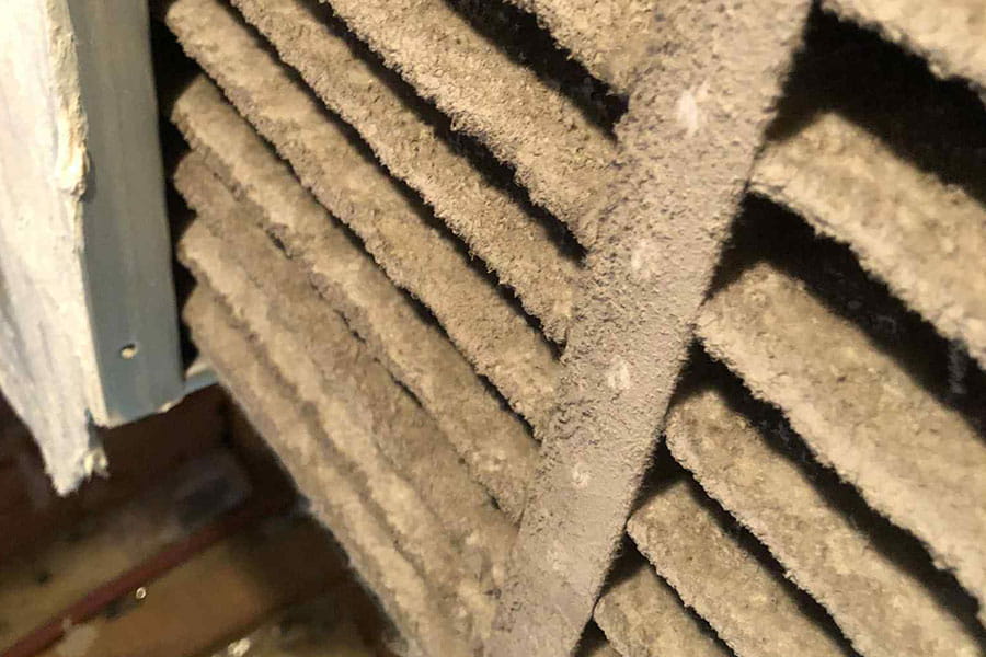 Dust-covered air filter clogged with debris buildup