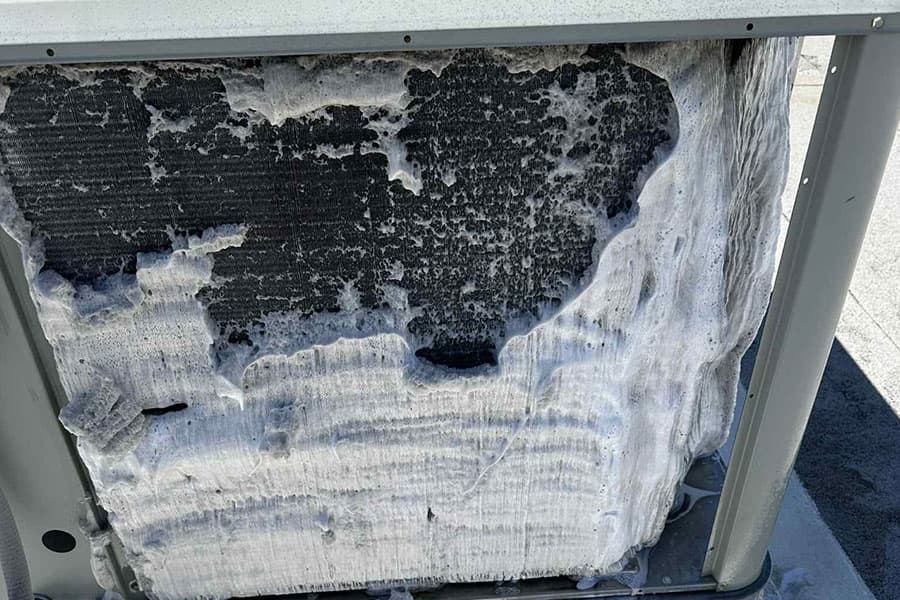 Outdoor AC coil covered in foaming cleaner during service in Las Vegas NV
