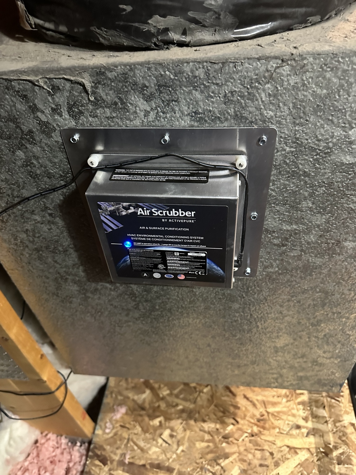 Air Scrubber mounted on metal HVAC ductwork with its indicator light illuminated.