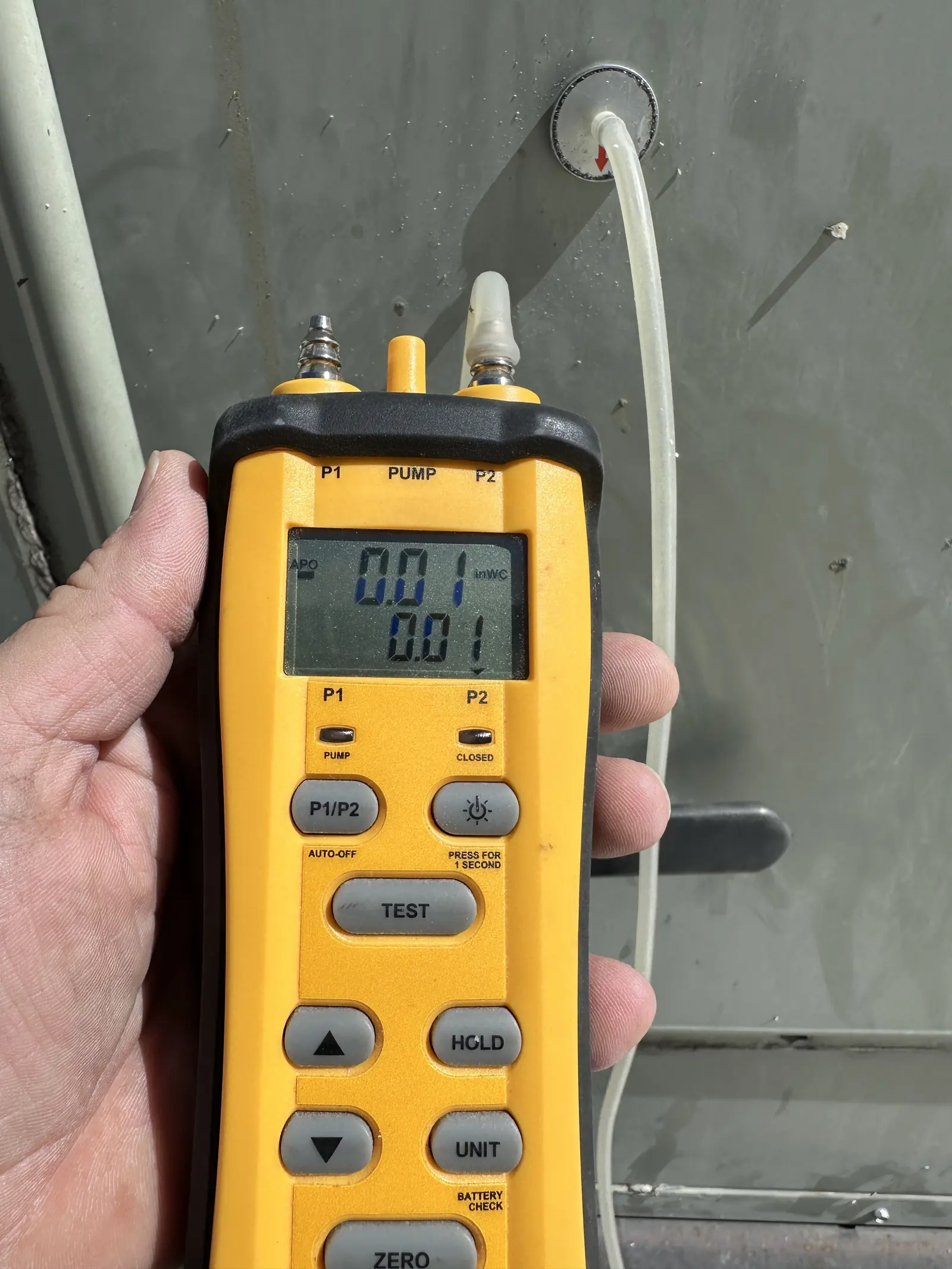Technician using a manometer to test duct static pressure